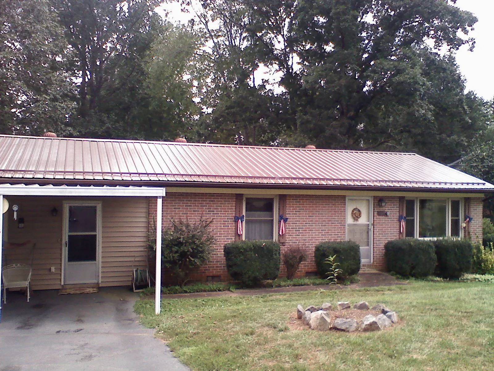 Bronze metal roof and carport on a brick ranch home — Roof Repair work by our crew in Palmetto
